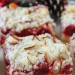 Modern Christmas cheesecake bars with vibrant cranberry swirl on white marble