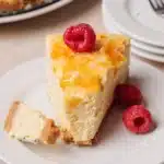 A modern glass bowl holding anti-inflammatory crème brûlée cheesecake on a bright white marble background.