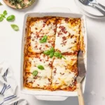 Clean eating plate of organic high protein ratatouille lasagna with chickpea pasta on a white marble backdrop.